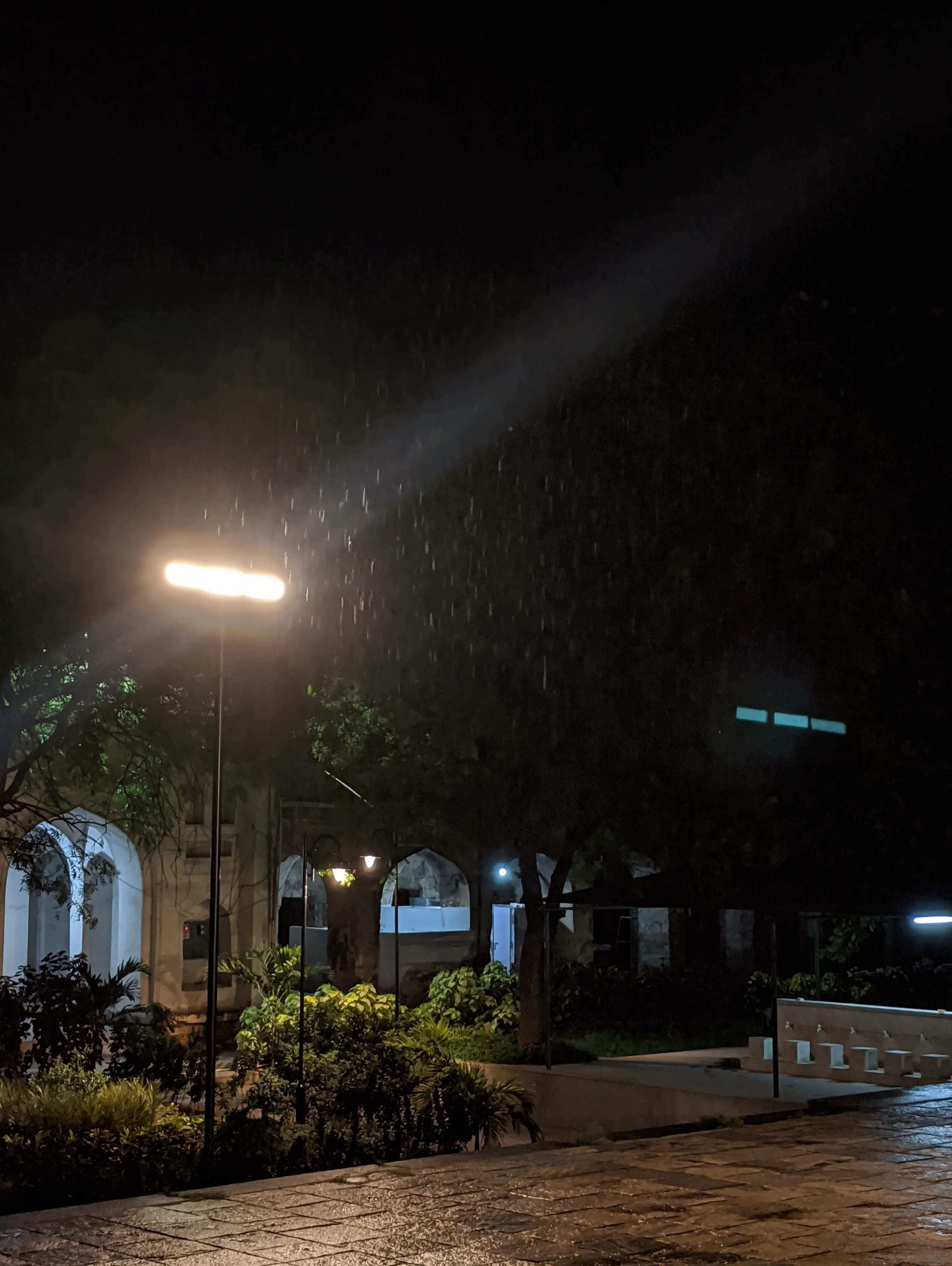 A street lamp in the rain at night